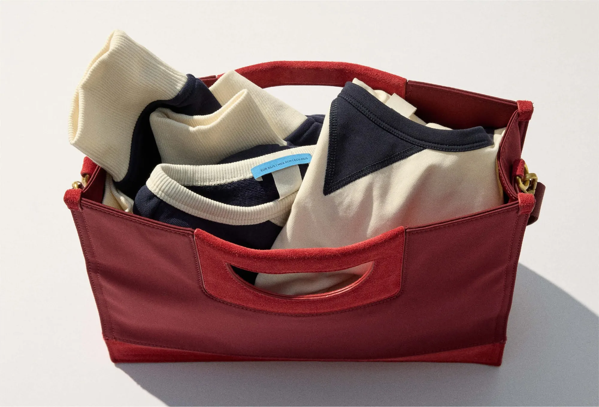 The red tote with cream and navy pieces folded inside