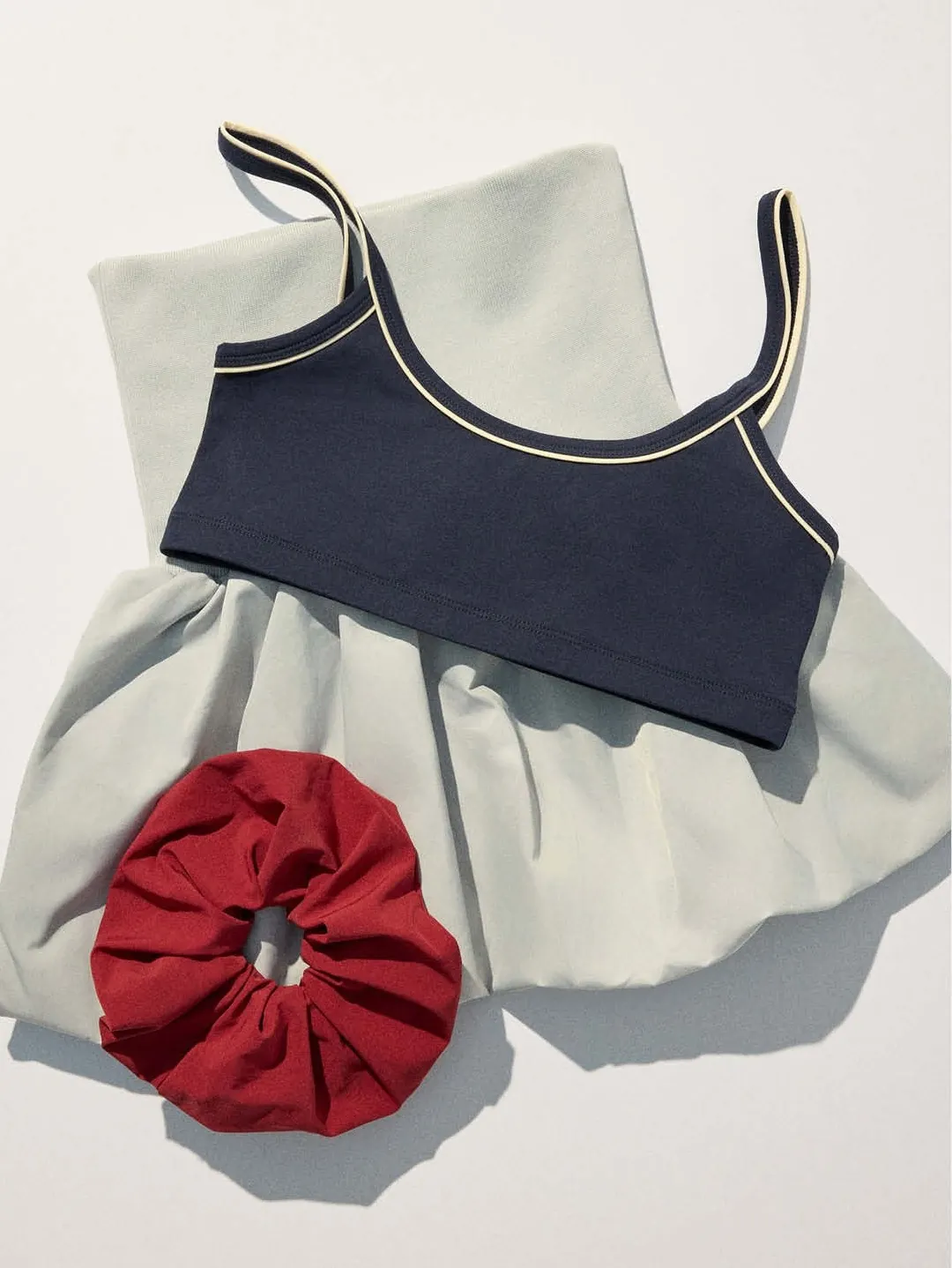 Flat lay: navy top over the pale grey skirt with a red chouchou