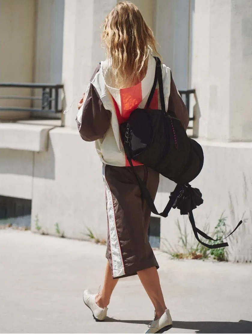 The navy zip cardigan over the black balloon skirt, iced coffee in hand