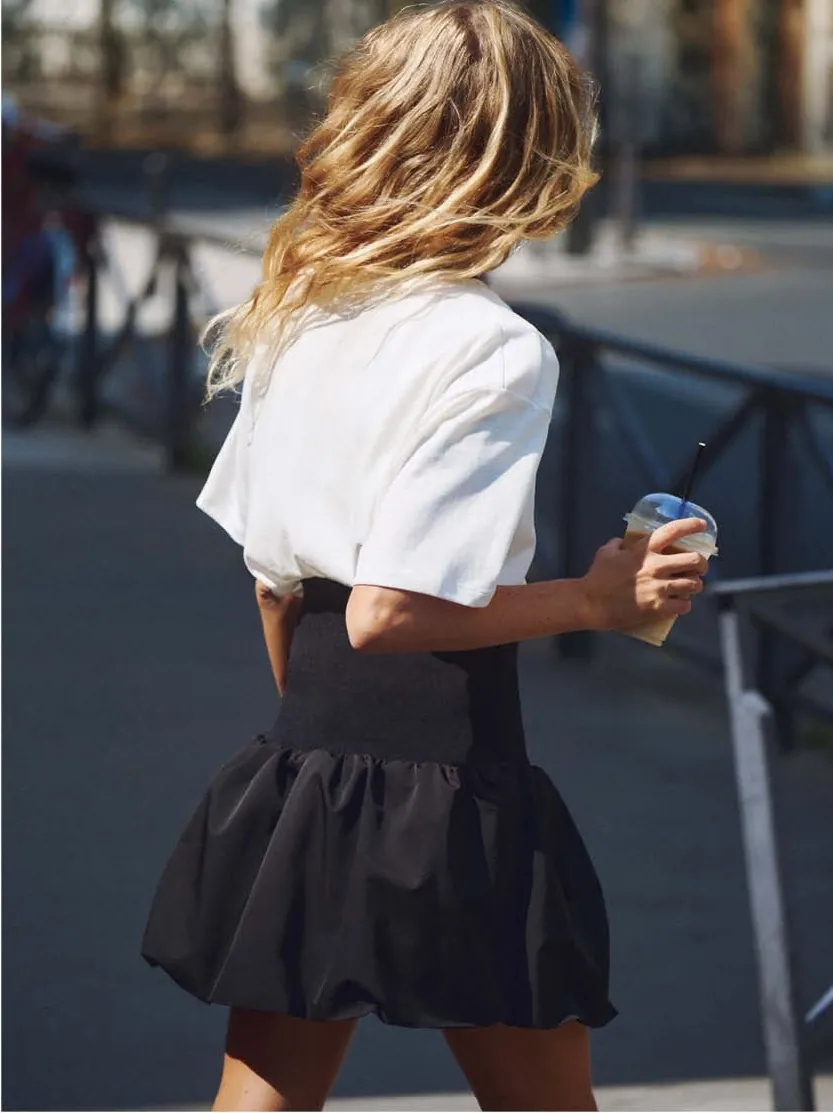 The black toiletry bag with sunglasses, ballet flats and a headband spilling out
