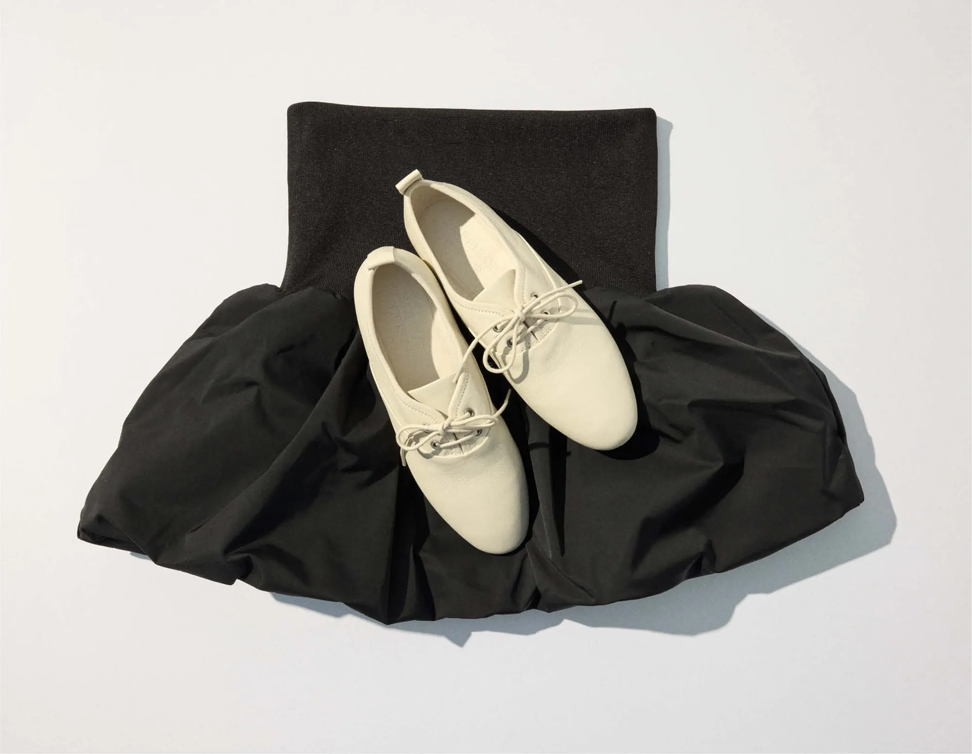 White shirt over the black balloon skirt, iced coffee and the black toiletry bag