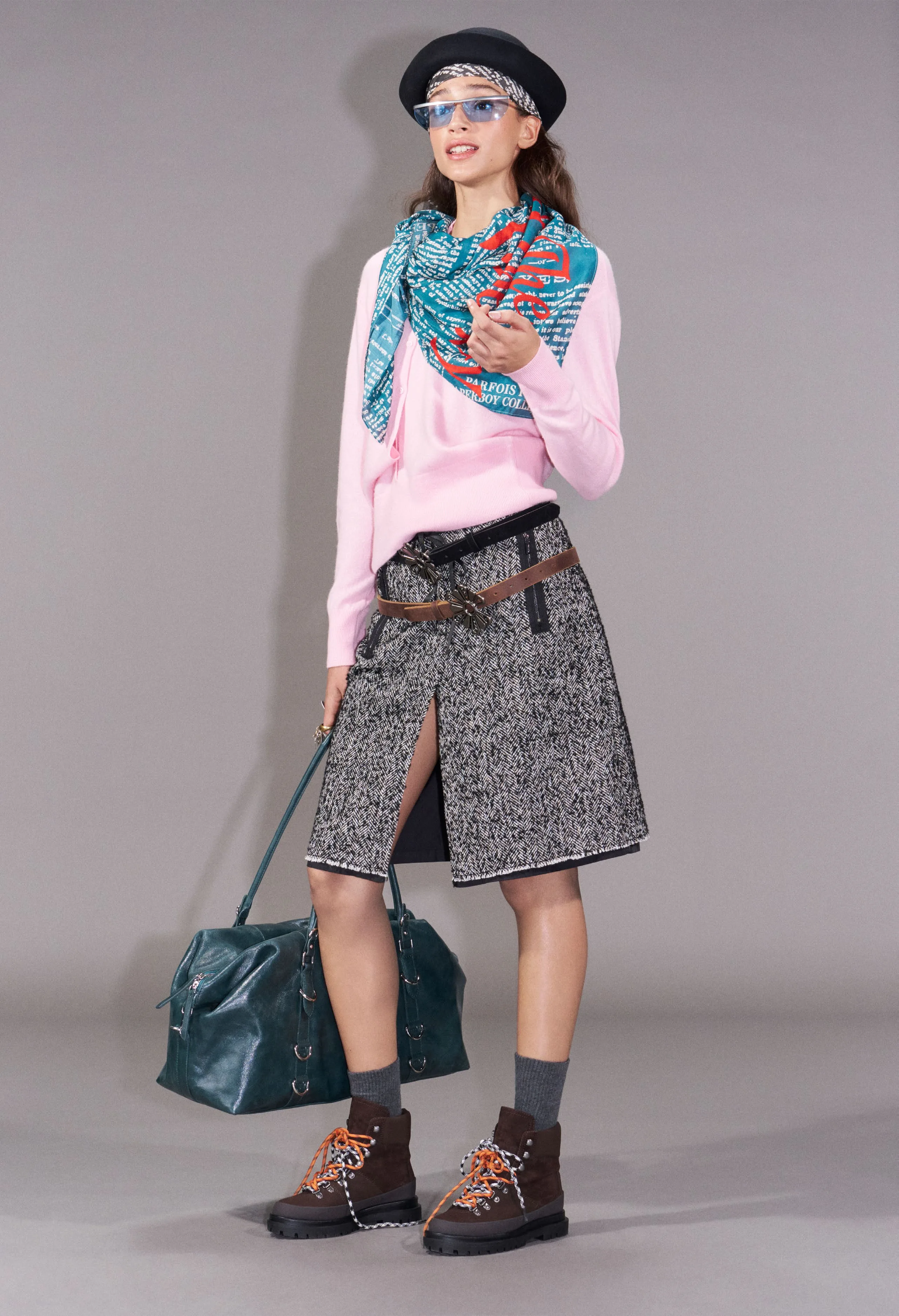 Catarina in a pink sweater, herringbone skirt and printed scarf