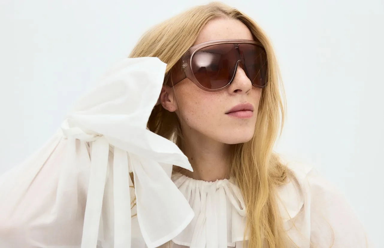 White ruffled blouse held closed, in profile
