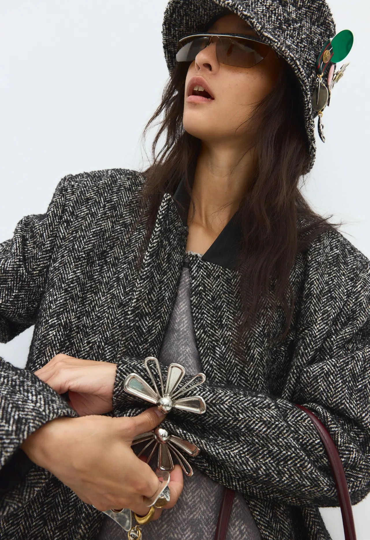 Bucket hat and a bow of dark ribbon, mid-gesture