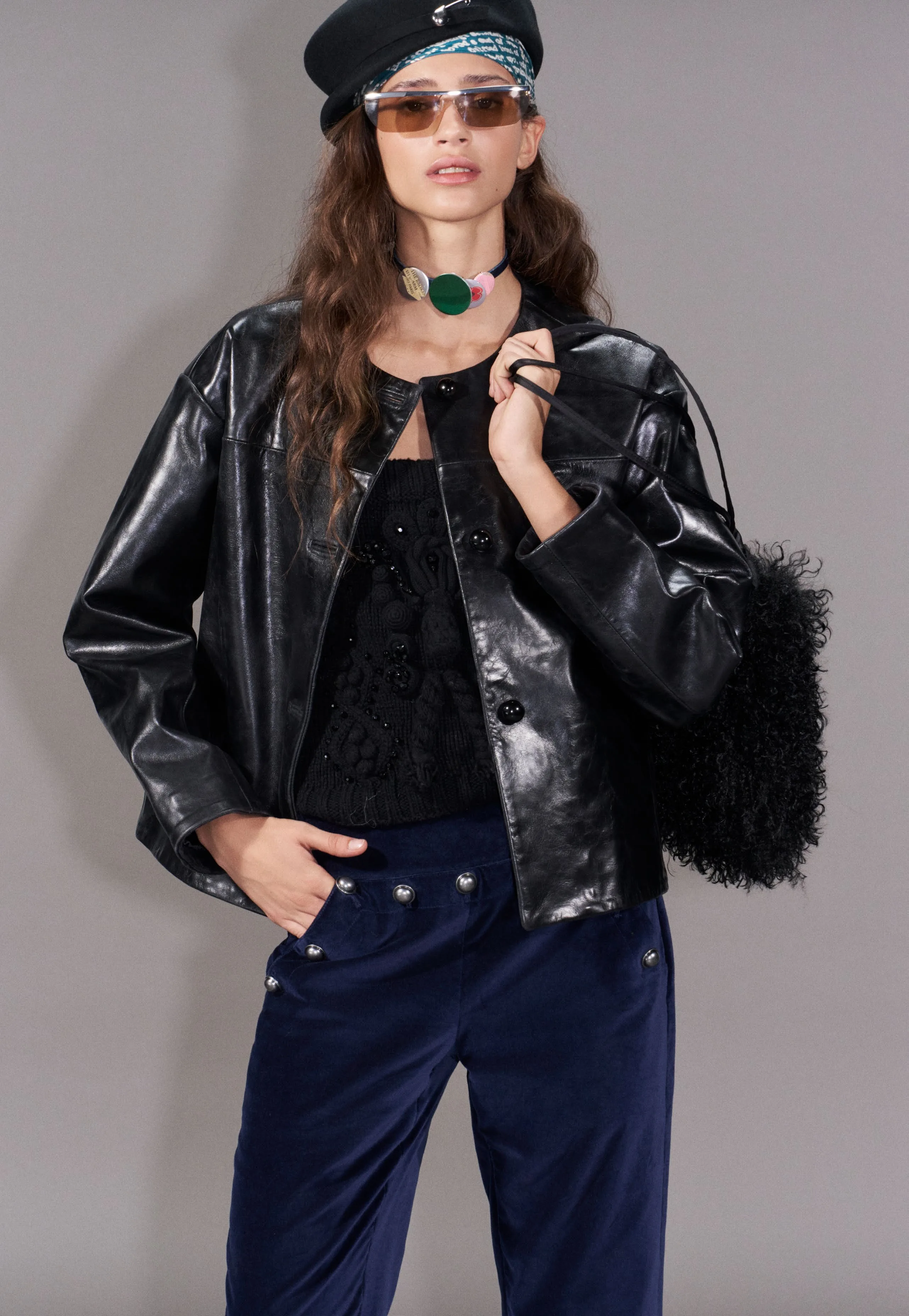 Patent leather jacket over navy velvet, statement necklace