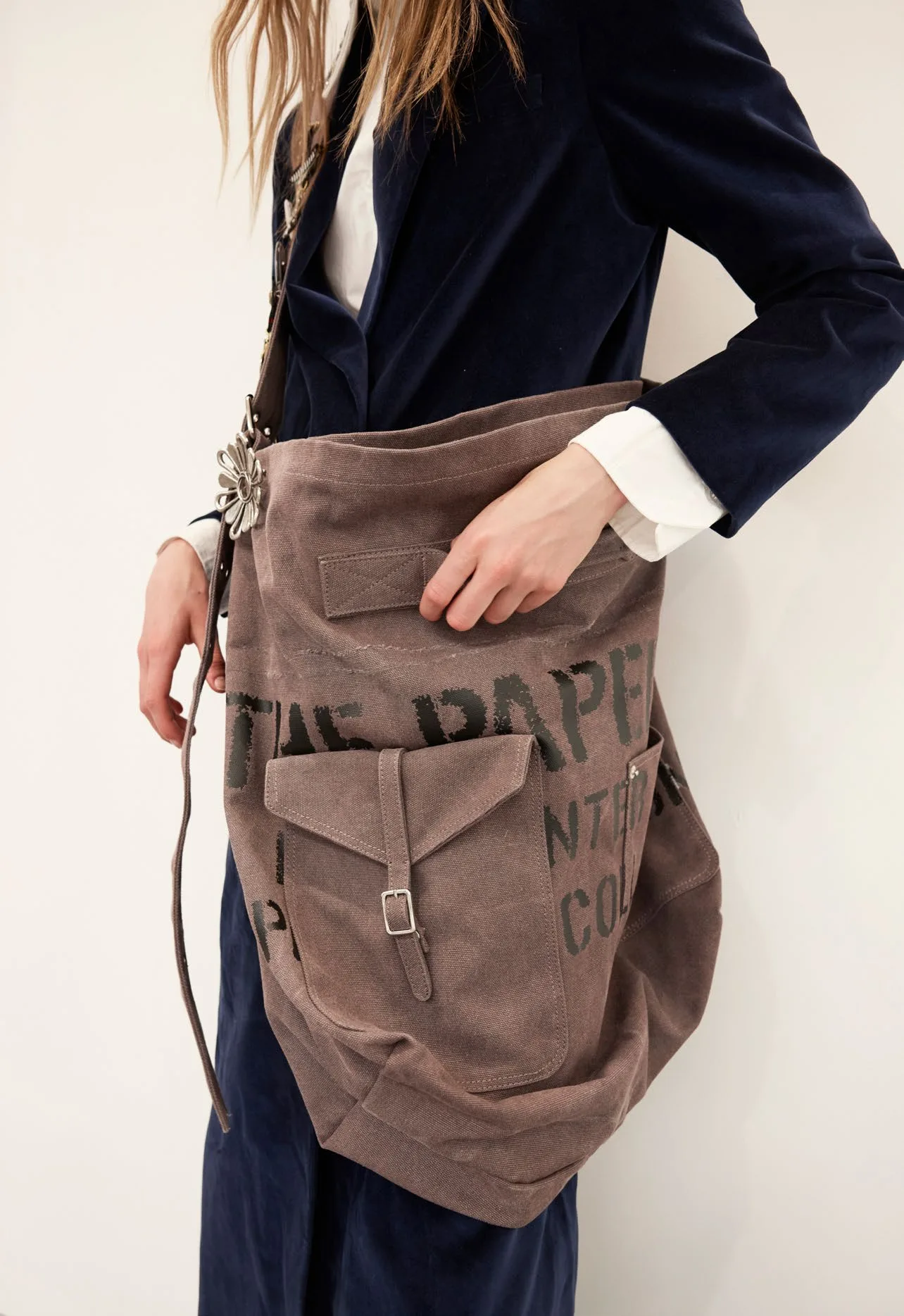 The canvas bag up close, stamped with the collection masthead