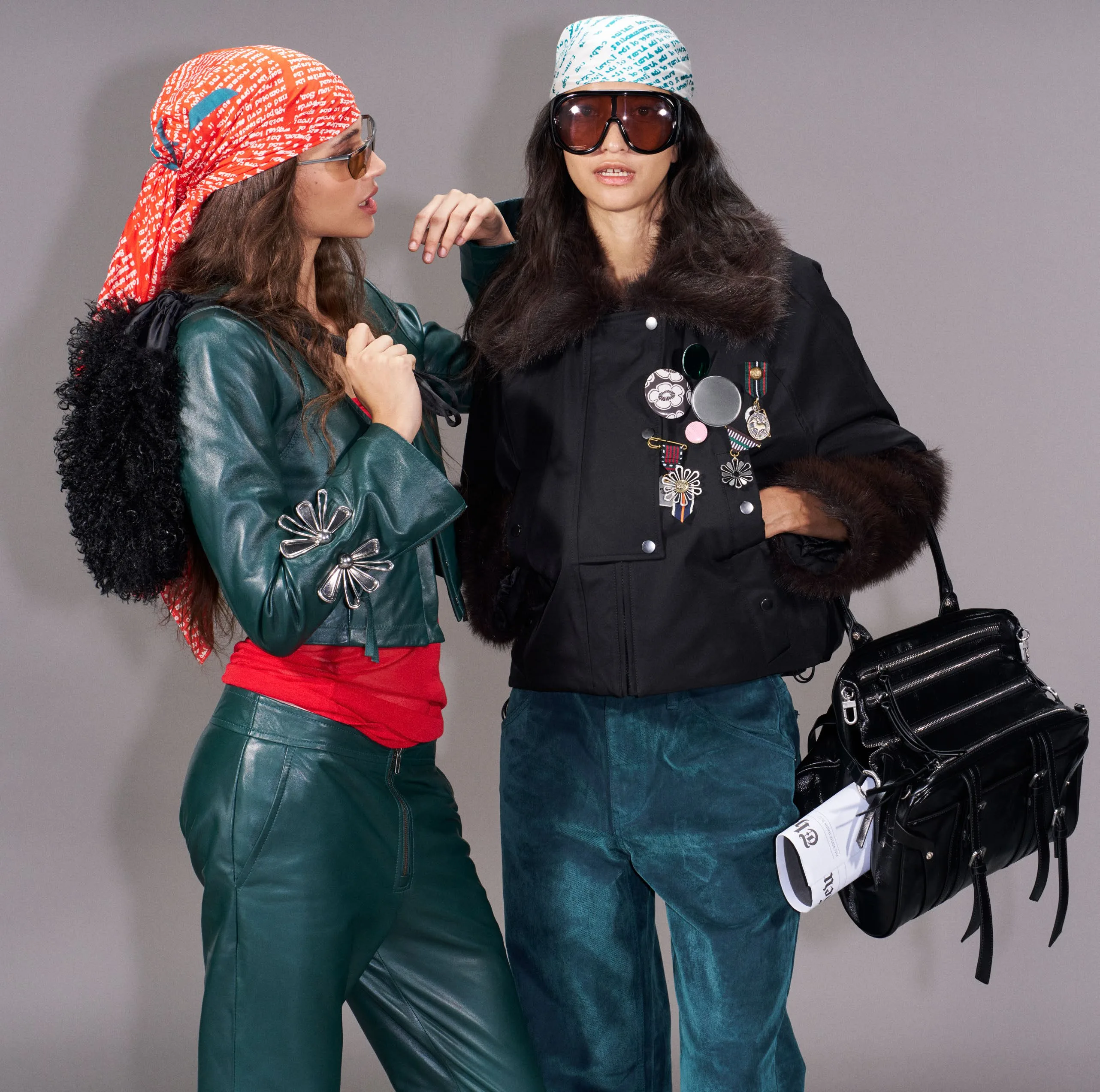 Two candidates in printed headscarves sharing the black studded bag