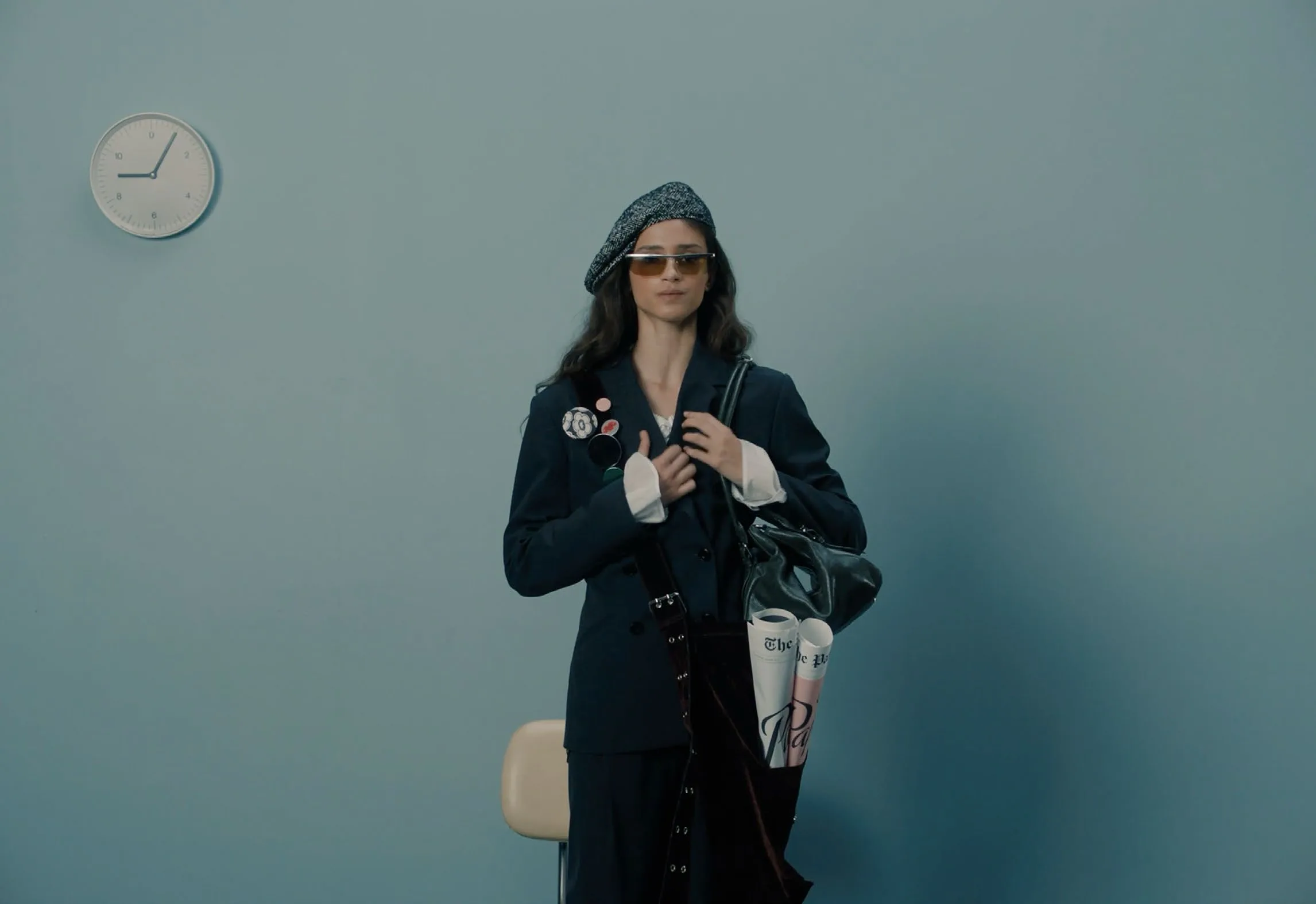 Casting tape: a candidate crosses the blue room with a white lettered bag